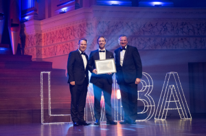 Vaulta CEO Dominic Spooner accepting the LMBA Award on stage with Lord Mayor and Urban Utilities CEO